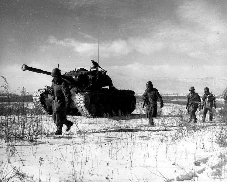A column of troops and armor of the 1st Marine Division move through communist Chinese lines during their successful breakout from the Chosin Reservoir in North Korea. The Marines were besieged when the Chinese entered the Korean War November 27, 1950, by sending 200,000 shock troops against Allied forces. (Wikimedia Commons)
