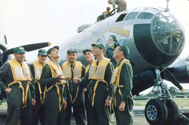 <em>Capt. Donald M. Covic makes a “command decision” by flipping a coin, just like the artwork on his B-29 (U.S. Air Force)</em>