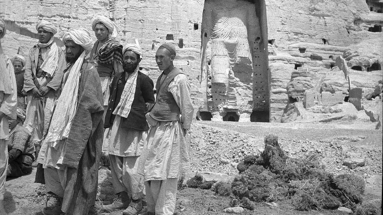 Local Afghan men standing near the larger "Salsal" Buddha statue, c. 1940. (Wikimedia Commons)