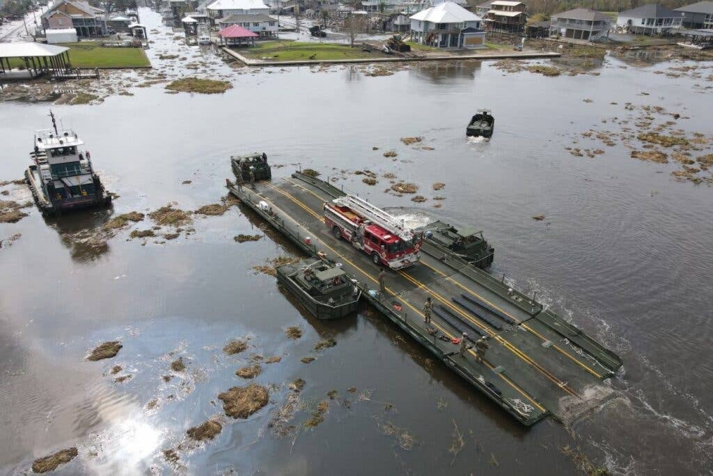 <em>The 2225th ferries first responders and their equipment on an IRB section before the bridge is completed (U.S. Army National Guard)</em>