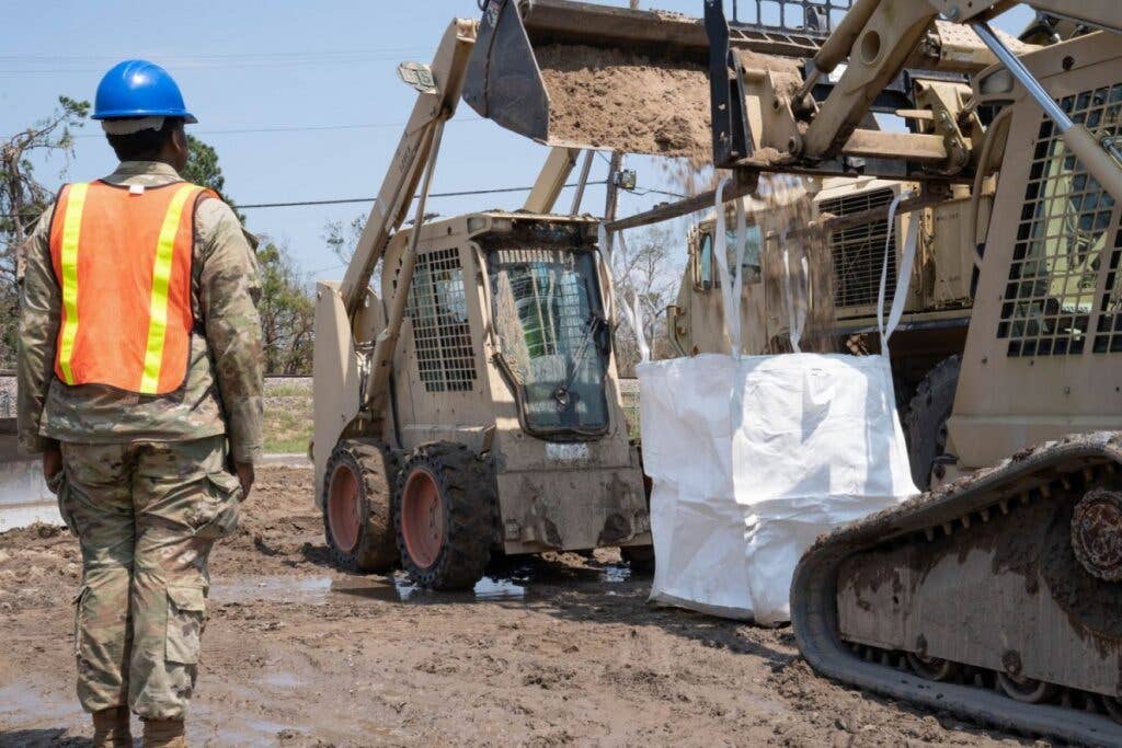 <em>Guardsmen of the 225th fill super sacks to assist in flooding blockade (U.S. Army National Guard)</em>