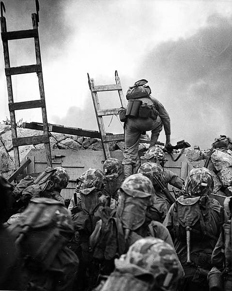 Lieutenant <a href="https://en.wikipedia.org/wiki/Baldomero_Lopez">Baldomero Lopez</a> of the Marine Corps is shown scaling a seawall after landing on Red Beach (September 15). Minutes after this photo was taken, Lopez was killed after covering a live grenade with his body.<sup> </sup>He was posthumously awarded the Medal of Honor. (Wikimedia Commons)