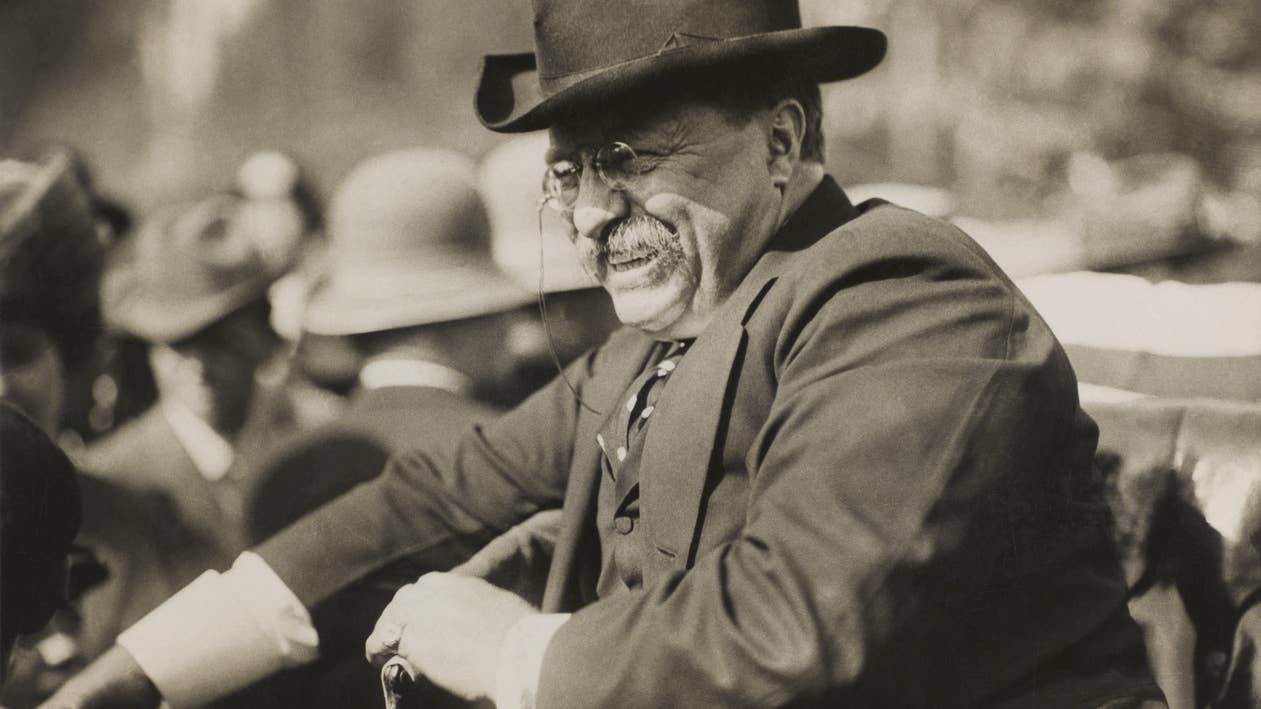 Photograph showing Theodore Roosevelt smiling from an automobile. (Wikipedia)