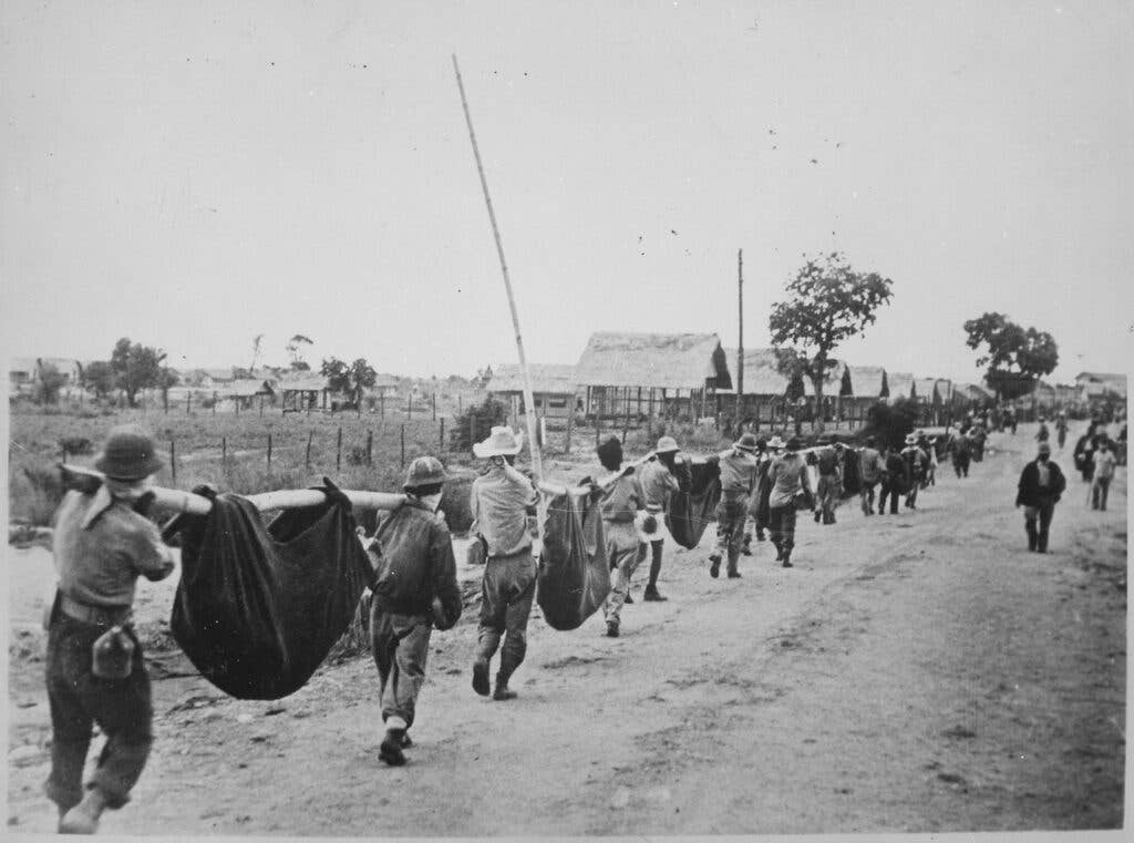 <em>American POWs carry their fallen comrades after the Bataan Death March at Camp O'Donnell (Public Domain)</em>