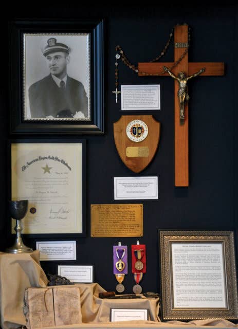 <em>The </em>Oklahoma<em> crucifix and Schmitt's personal belongings on display at Christ the King Chapel (Loras College)</em>