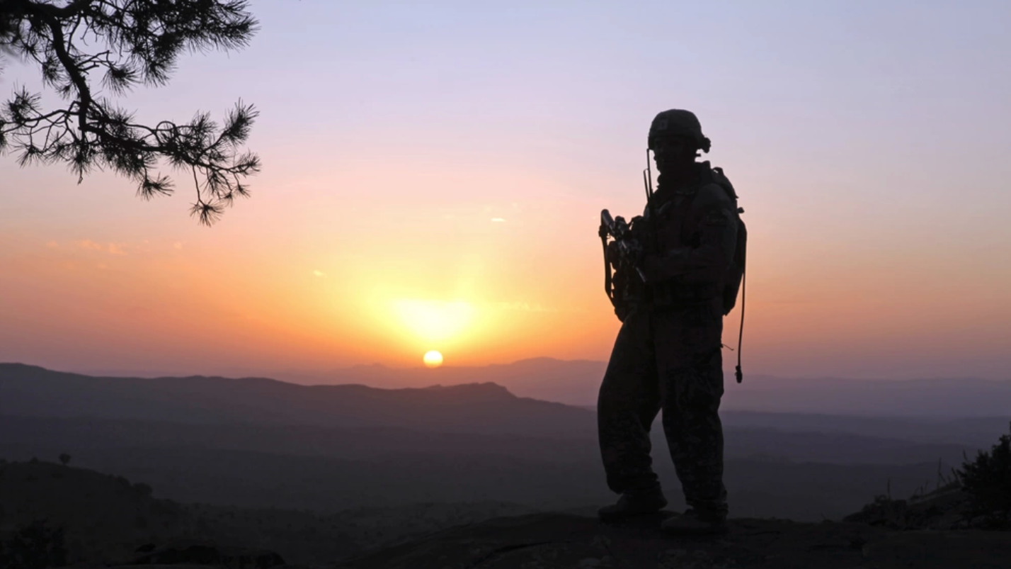 A soldier patrols during sunset, in the mountains of Afghanistan. U.S. Army photo. 