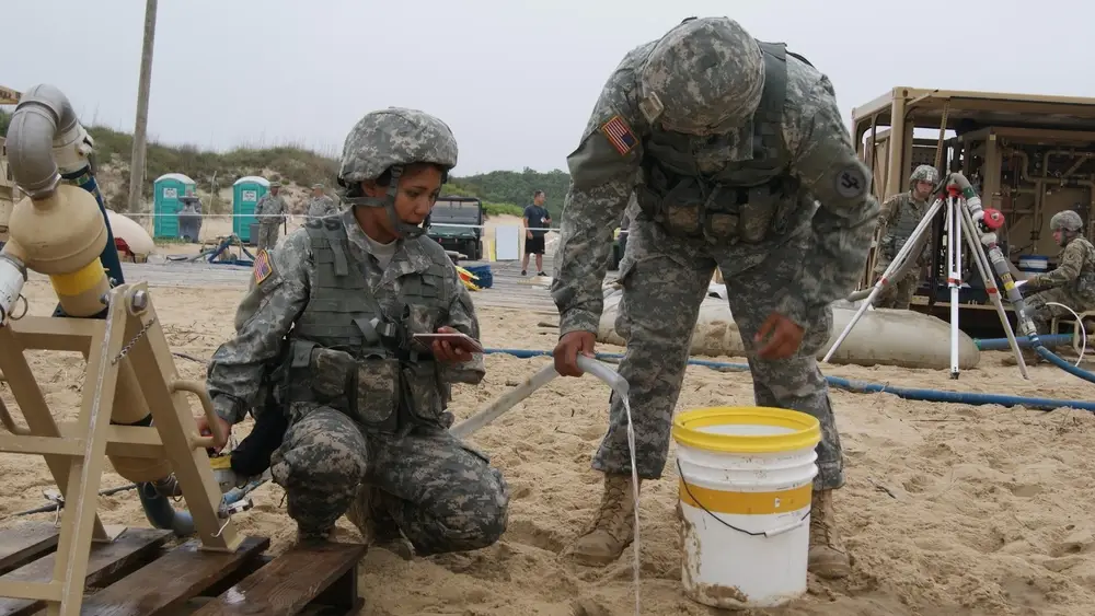 Sgt. Monika MacDonald and Private 1st Class Miguel Arroyo, members of the 753rd Quartermaster Company water purification team, drain the cyclone separator as they shut down operations at the Reverse Osmosis Water Purification Unit Rodeo at Fort Story, Virginia. (DVIDS)