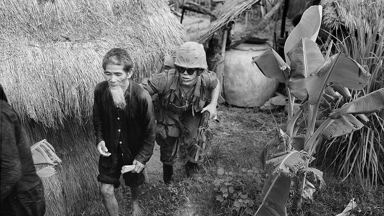 A Marine from 1st Battalion, 3rd Marines, moves a suspected Viet Cong during a search and clear operation held by the battalion 15 miles (24 km) west of Da Nang Air Base, 1965. (USMC photo)