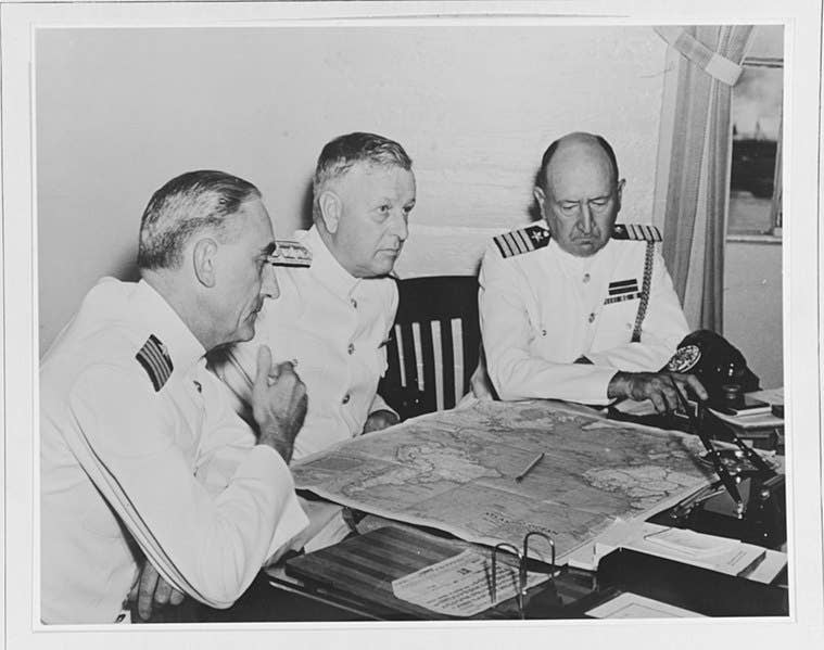 Kimmel (center) confers with his Chief of Staff, <a href="https://en.wikipedia.org/wiki/William_W._Smith_(admiral)">William "Poco" Smith</a>; and Operations Officer and Assistant Chief of Staff, Captain <a href="https://en.wikipedia.org/w/index.php?title=Walter_S._DeLany&amp;action=edit&amp;redlink=1">Walter S. DeLany</a> (left), at Pearl Harbor, 1941.