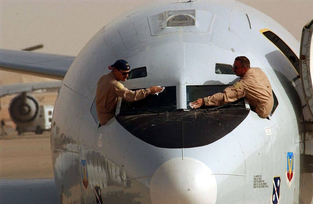 <em>JSTARS pilots clean the windshields of their E-8 before a mission in Iraq (U.S. Air Force)</em>