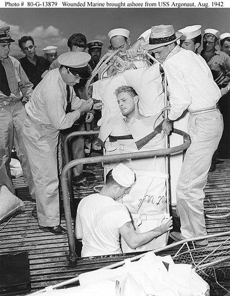 A Marine Raider, injured during the Makin Raid, is lifted through a hatch on USS Argonaut (SM-1) to be taken ashore at Pearl Harbor, 26 August 1942. (U.S. Navy photo)