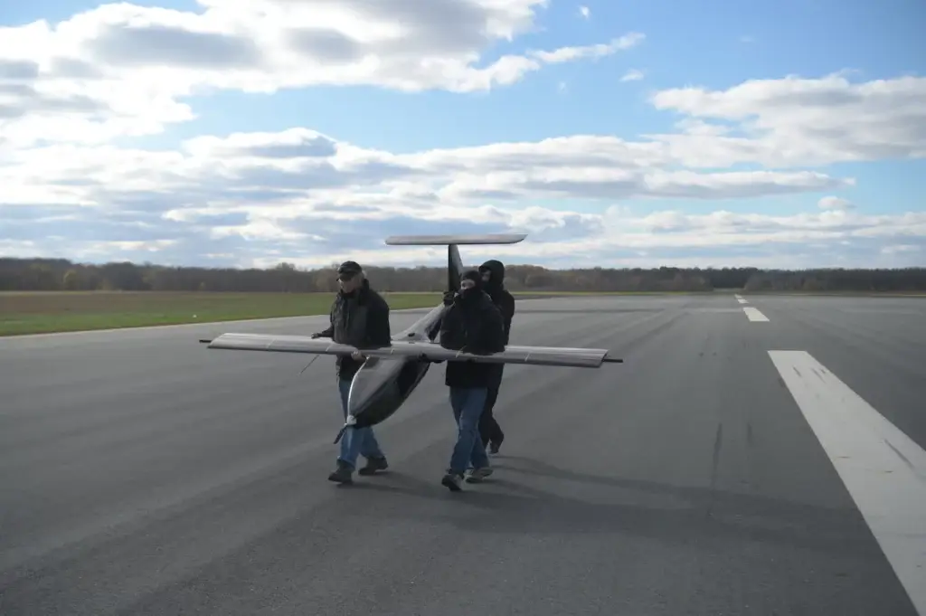 <em>NRL engineers carry the Hybrid Tiger UAV out to the flightline (U.S. Navy)</em>