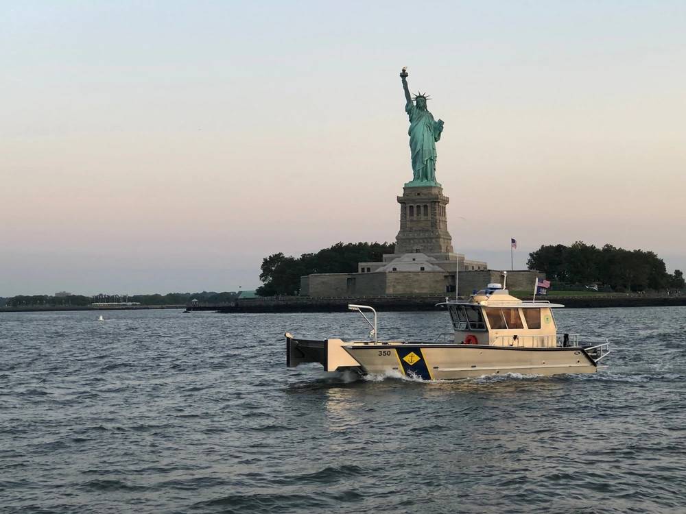 <em>A New York Naval Militia boat sails past the Statue of Liberty (New York National Guard)</em>