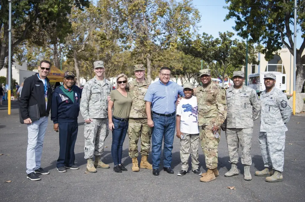 Veterans and family pose at an annual event dedicated to helping homeless veterans, veterans and the family of veterans by providing them with an array of services, food, and the opportunity to connect with other veterans and active duty members. (U.S. Air Force photo by Airman 1st Class Hanah Abercrombie)