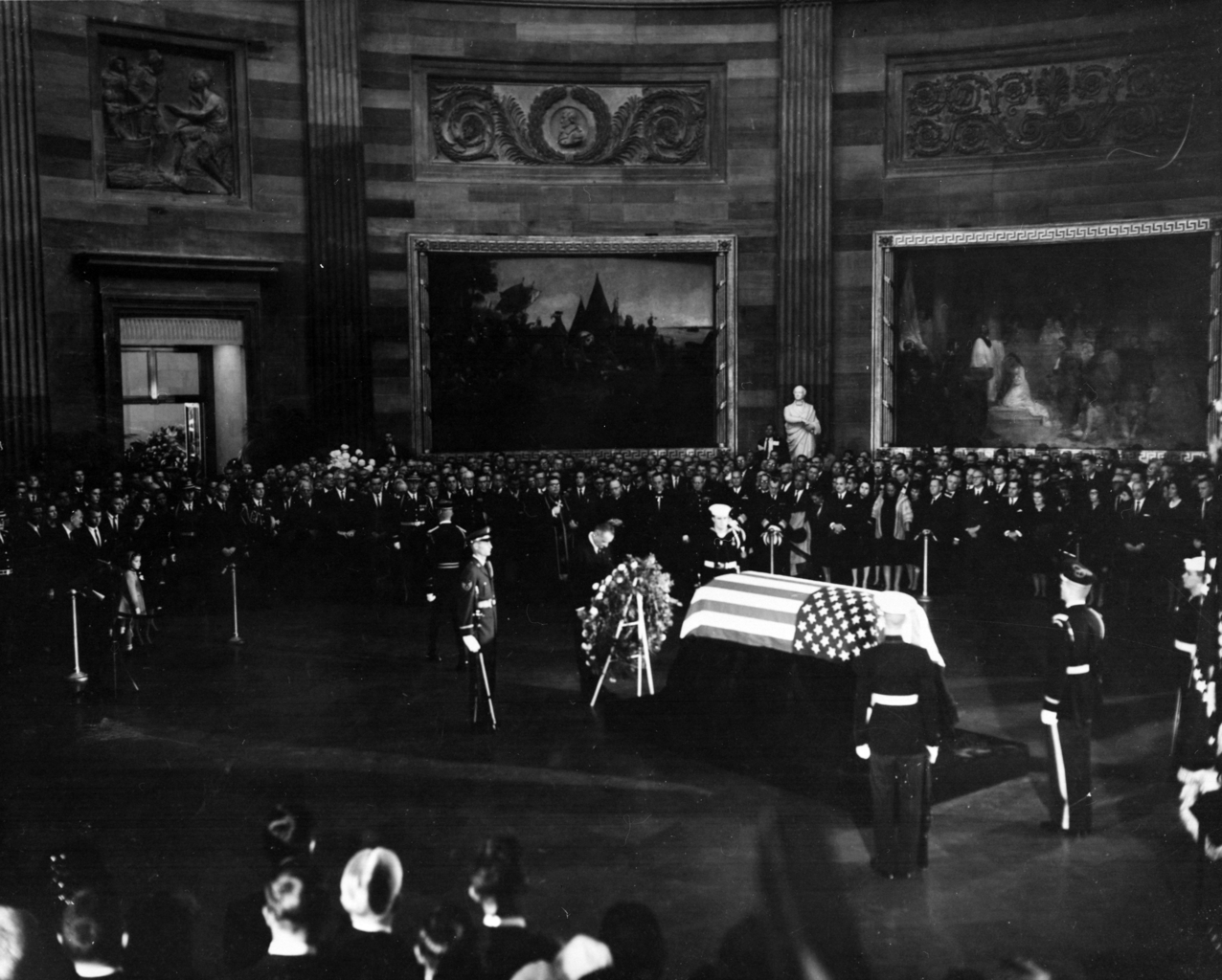 Photograph of President Lyndon B. Johnson placing a wreath before the flag-draped casket of President John F. Kennedy, during funeral services for Kennedy in the Capitol rotunda. (Public domain)