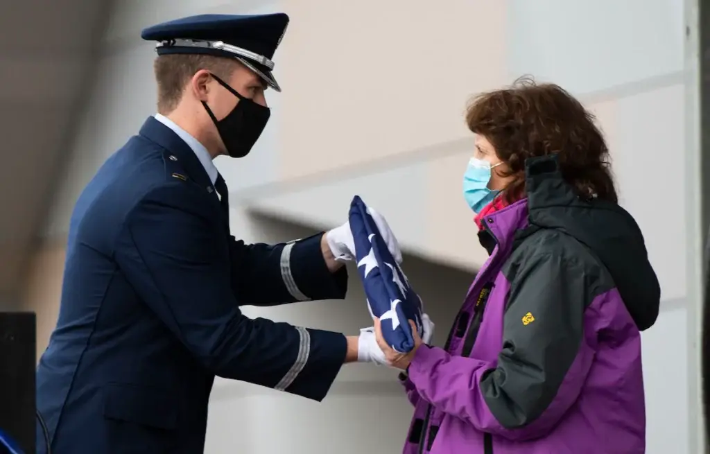 <em>An Honor Guardsman presents the folded American flag to Chuck Yeager's widow, Victoria Scott D'Angelo (U.S. Air Force)</em>
