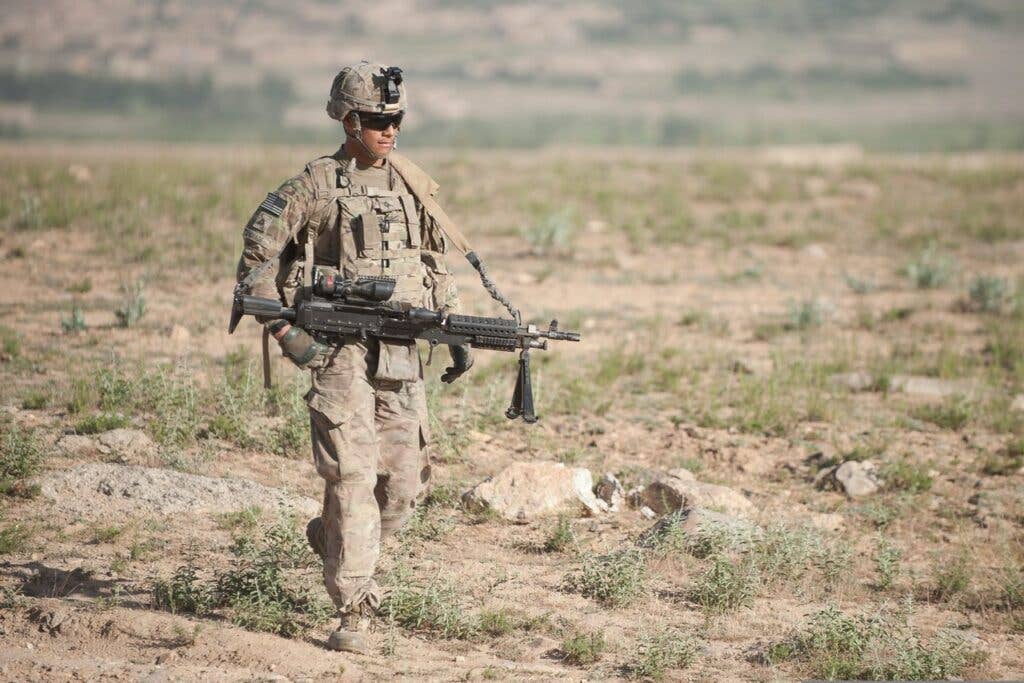 <em>A soldier carries an M240L in Afghanistan (U.S. Army)</em>