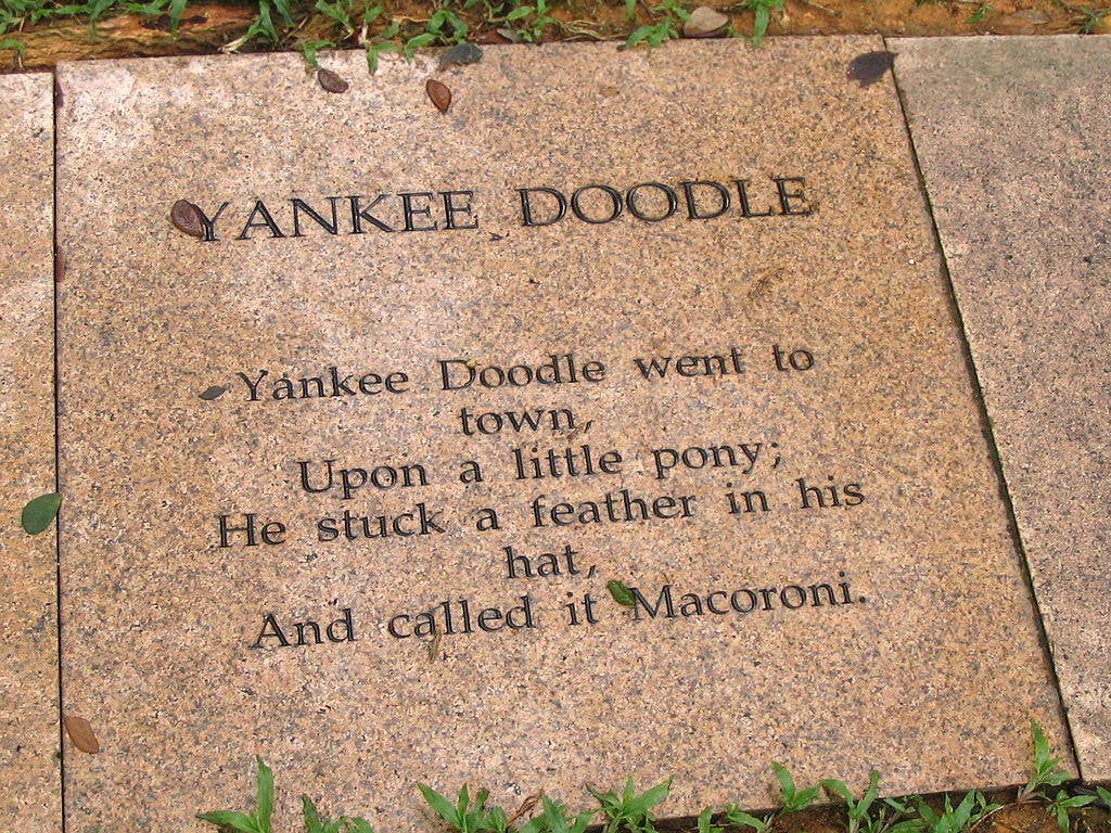 The first verse and refrain of <em>Yankee Doodle</em>, engraved on the footpath in a park.