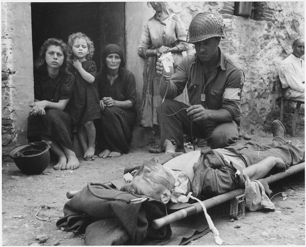 Wounded soldier is given blood plasma in Sicily, 1943.