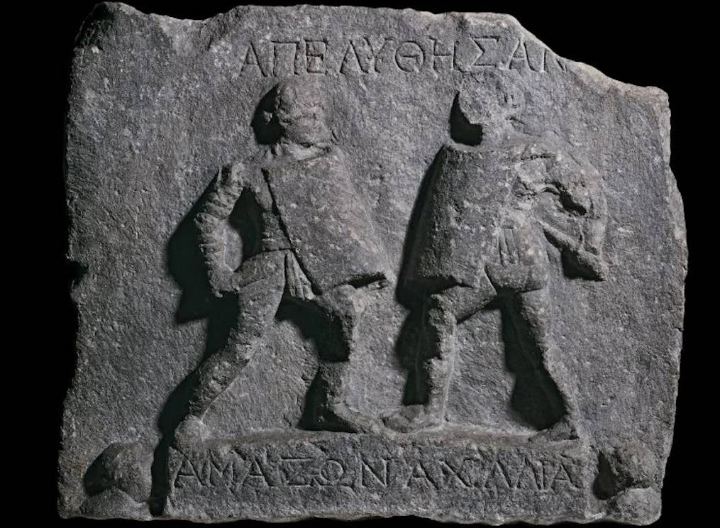 Relief of paired fighters, Amazonia and Achillea, found at Halicarnassus. Their name-forms identify them as female. (Public domain)