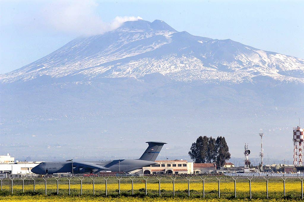 030325-N-9693M-001.Naval Air Station Sigonella, Sicily (March 25, 2003) -- Sicily's volcano, Mt. Etna, is the backdrop for a U.S. Air Force C-5 "Galaxy" and the air terminal of Naval Air Station (NAS) Sigonella. NAS Sigonella provides logistical support for Sixth Fleet and NATO forces in the Mediterranean Sea. U.S. Navy photo by Photographer's Mate 2nd Class Damon J. Moritz. (RELEASED).