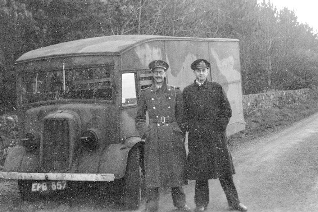 Charles Cholmondeley and Ewen Montagu, two of the British intelligence officers involved in the planning of Operation Mincemeat, shown in front of the vehicle transporting the body of Glyndwr Michael for pick up by submarine.