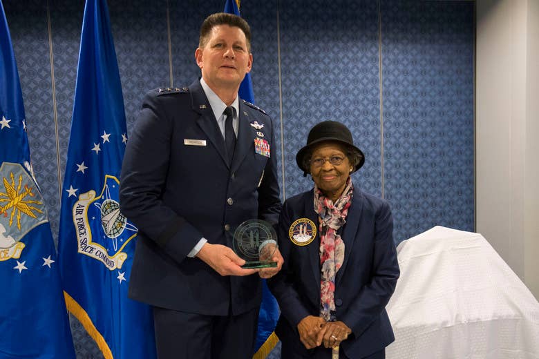 Air Force Space Command Vice Commander Lt. Gen. DT Thompson delivers presents Dr. Gladys West  with an award as she is inducted into the Air Force Space and Missile Pioneers Hall of Fame during a ceremony in her honor at the Pentagon in Washington, D.C., Dec. 6, 2018. West was among the so-called "Hidden Figures" part of the team who did computing for the U.S. military in the era before electronic systems. The Air Force Space and Missile Pioneers Hall of Fame is one of Air Force's Space Commands Highest Honors.(Photo by Adrian Cadiz)