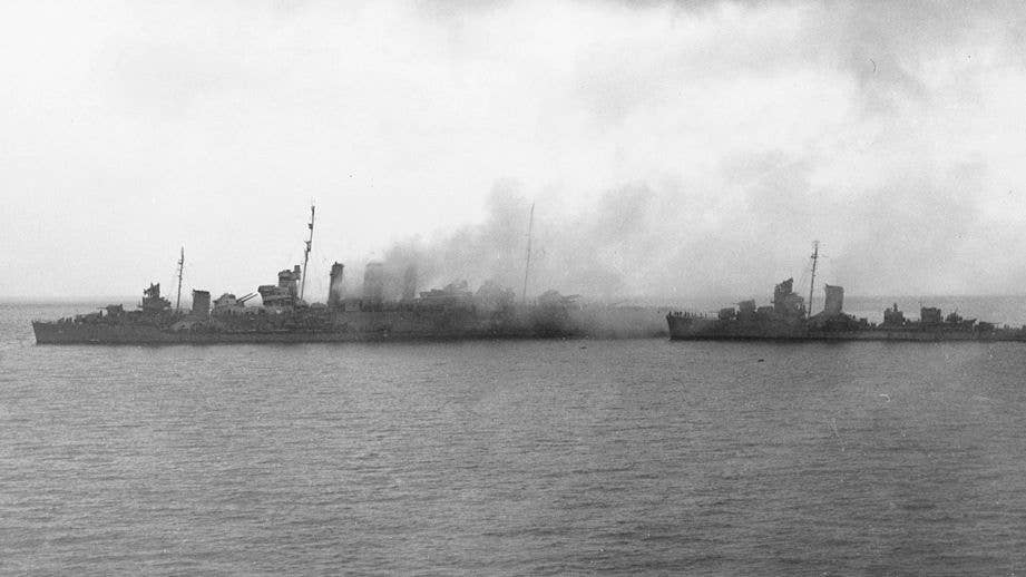  	U.S. Navy destroyers remove the crew from the sinking Royal Australian Navy heavy cruiser HMAS Canberra (D33) after the Battle of Savo Island, 9 August 1942. USS Blue (DD-387) is alongside Canberra´s port bow, as USS Patterson (DD-392) approaches from astern.