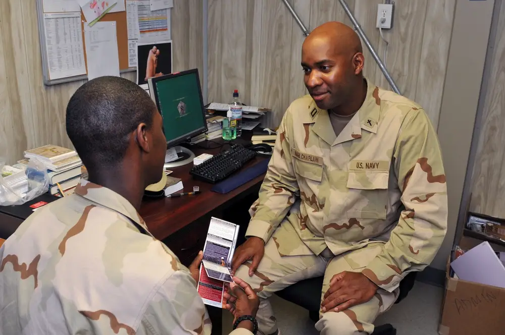 Navy Chaplain Lt. Anthony Carr, deployed to Joint Task Force Guantanamo with the Navy Expeditionary Guard Battalion, listens to Navy Petty Officer 3rd Class Montavious Jackson, 2010. (Photo by <a href="https://www.dvidshub.net/portfolio/1065135/athneil-thomas">Sgt. Athneil Thomas</a>)