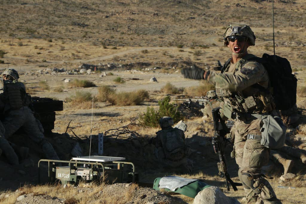 A U.S. Army Soldier assigned to 2nd Brigade Combat Team, 2nd Infantry Division uses hand signals as he commands his team while in a Live Fire Exercise during Decisive Action Rotation 17-09 at Fort Irwin, Ca., Sept. 21, 2017. (U.S. Army photo by Spc. Courtney Jimenez, Operations Group, National Training Center)