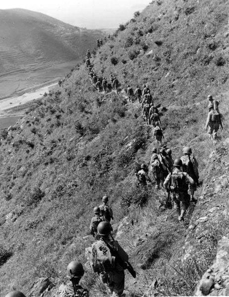 US Marines move out over rugged mountain terrain while closing with North Korean forces.