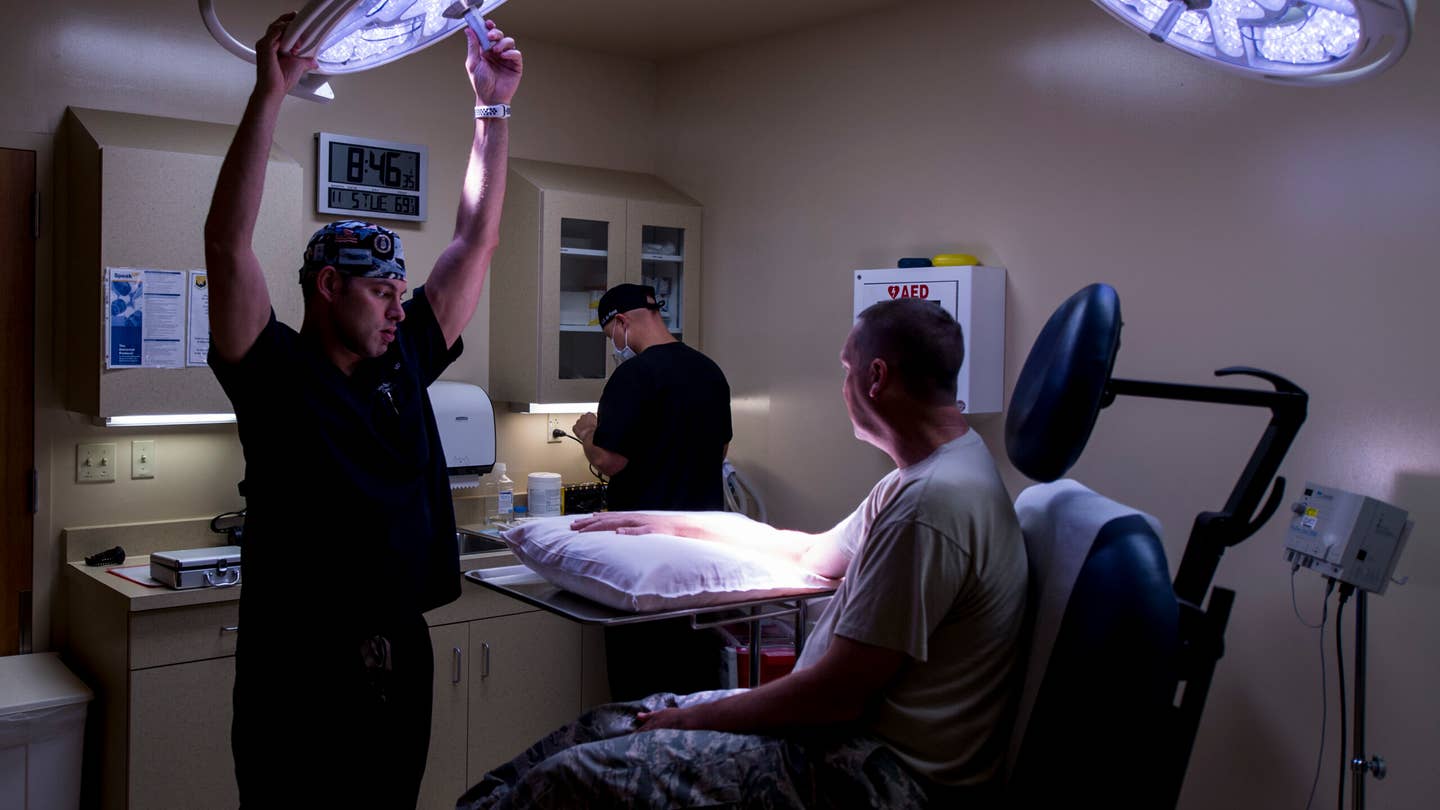 U.S. Air Force Maj. Thomas Beachkofsky, 6th Healthcare Operations Squadron (HCOS) dermatologist and Staff Sgt. Dalton Mace, 6th HCOS aerospace medical technician, prepare Lt. Col. Kurtis Kobes, a patient, for a procedure at MacDill Air Force Base, Fla., Nov. 5, 2019. With the help of a new dermatological analyzing software, Beachkofsky was able to diagnose a spot as an early stage of melanoma on Kobes and remove the area of skin before it could develop into deeper layers of skin. (U.S. Air Force photo by Senior Airman Adam R. Shanks)
