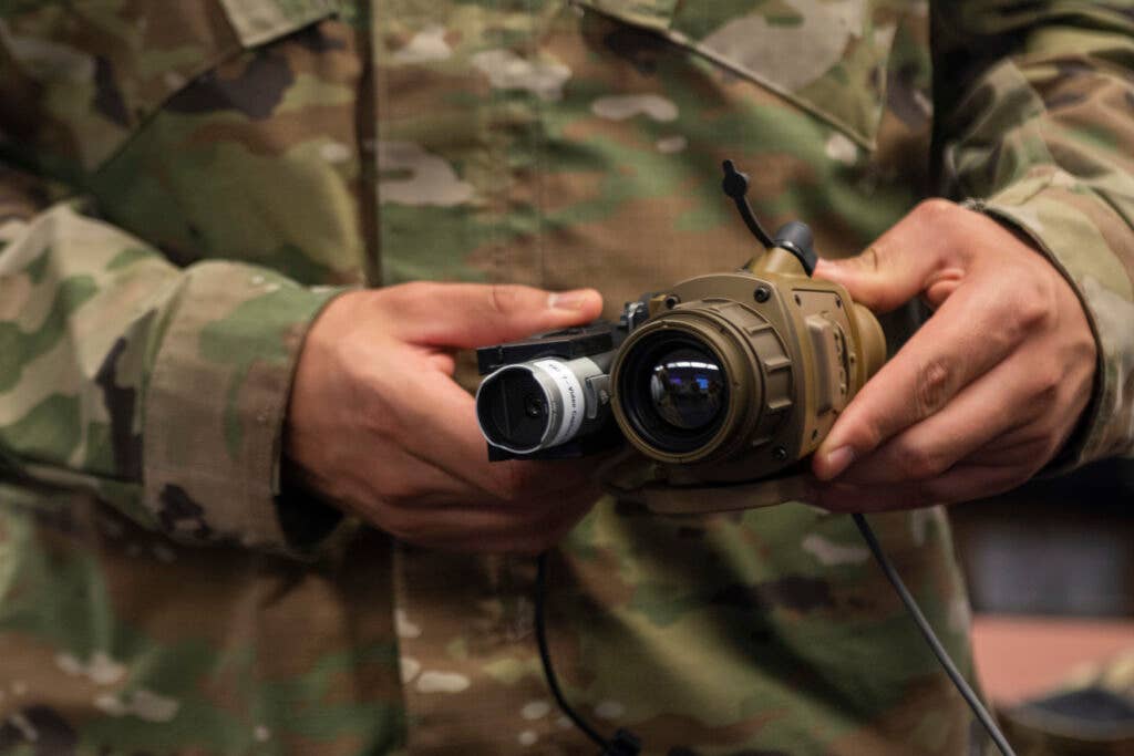 A U.S. Army Soldier inspects a Thermal Imaging for Fever Screening system during a training at Joint Base Langley-Eustis, Virginia, June 10, 2020. A secondary screen using a non-contact forehead thermometer will be used if an elevated temperature is detected during the thermal-screening process. (U.S. Air Force photo by Staff Sgt. Kaylee Dubois)