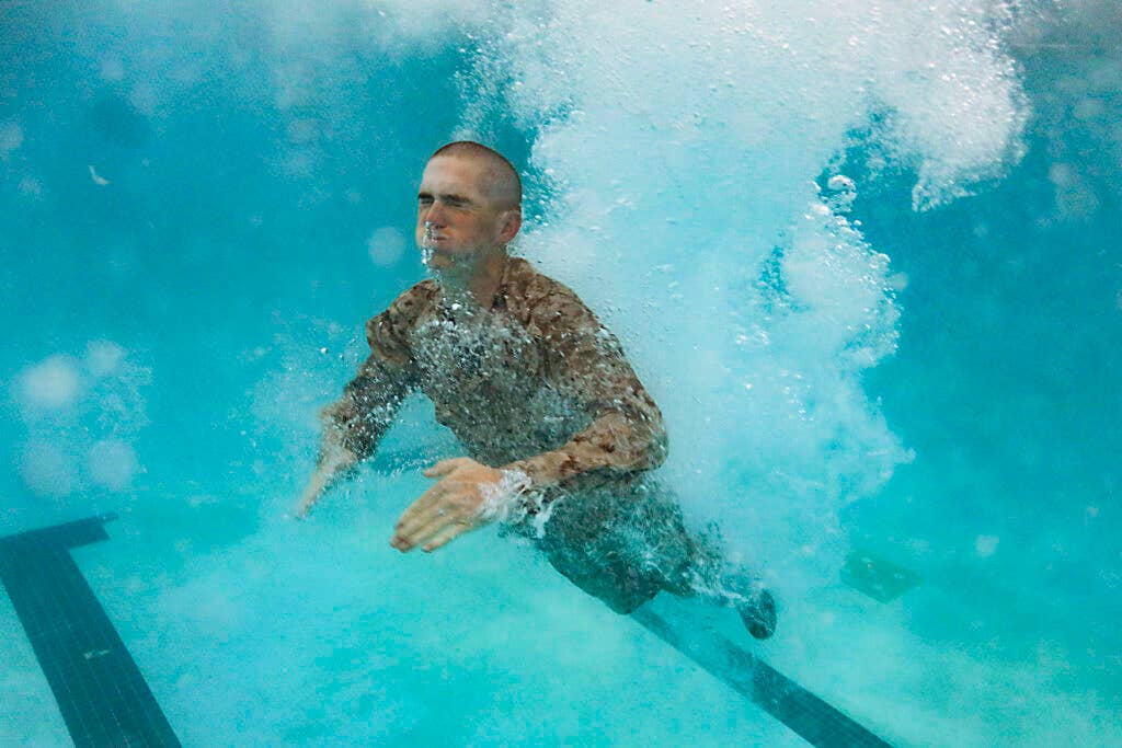 A U.S. Marine Corps recruit with India Company,  1st Recruit Training Battalion, conducts swim qualification at the combat training pool on Marine Corps Recruit Depot, Parris Island, S.C., Sept. 16, 2020. After demonstrations, recruits are tested on their ability to jump into deep water, shed proper equipment, and tread water in full utilities. (U.S. Marine Corps Photo by Cpl. Shane Manson)