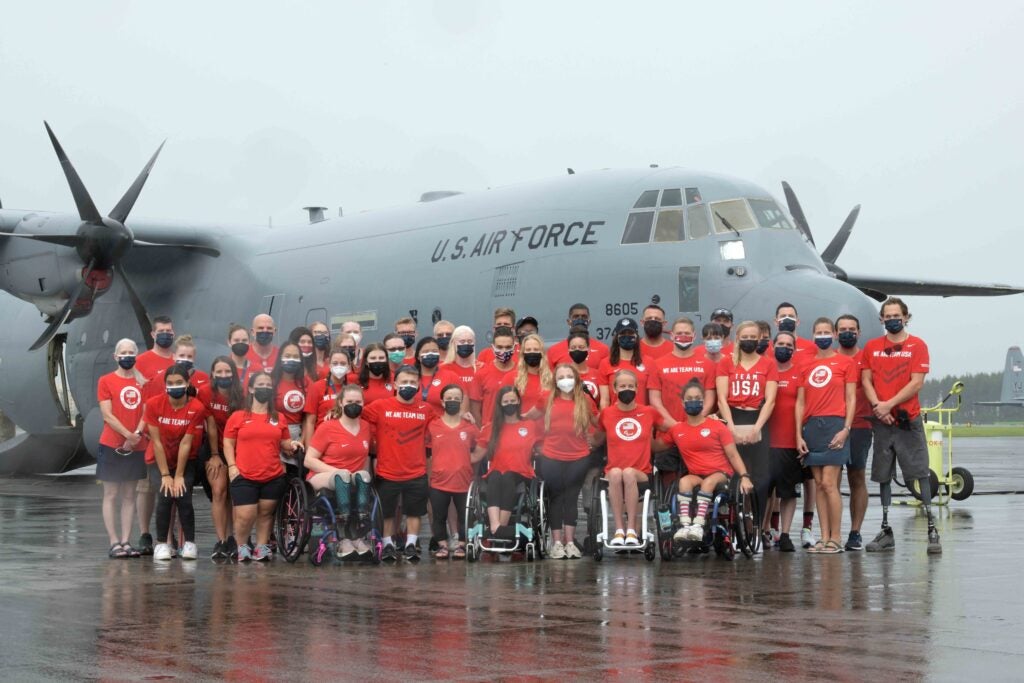 U.S. Paralympic Team poses in front of a C-130J Super Hercules at Yokota Air Base