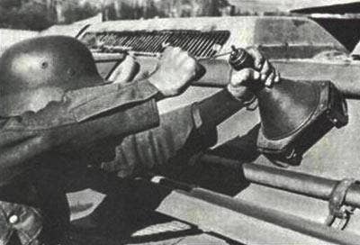 <em>A German soldier demonstrates the proper placement of the </em>Hafthohlladung<em> on a Soviet T-34 tank (Bundesarchiv)</em>