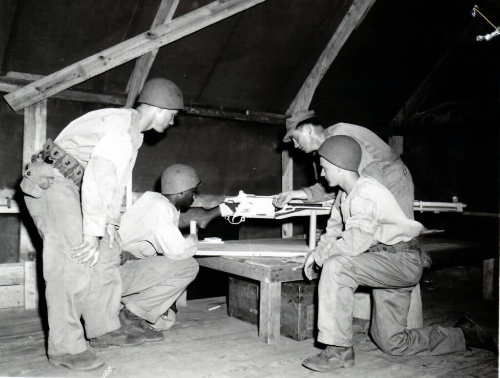 <em>A Marine instructs three recruits on the operation of the M1 using an M24 training aid at Parris Island, 1952 <em><em>(U.S. National Archives and Records Administration)</em></em></em>