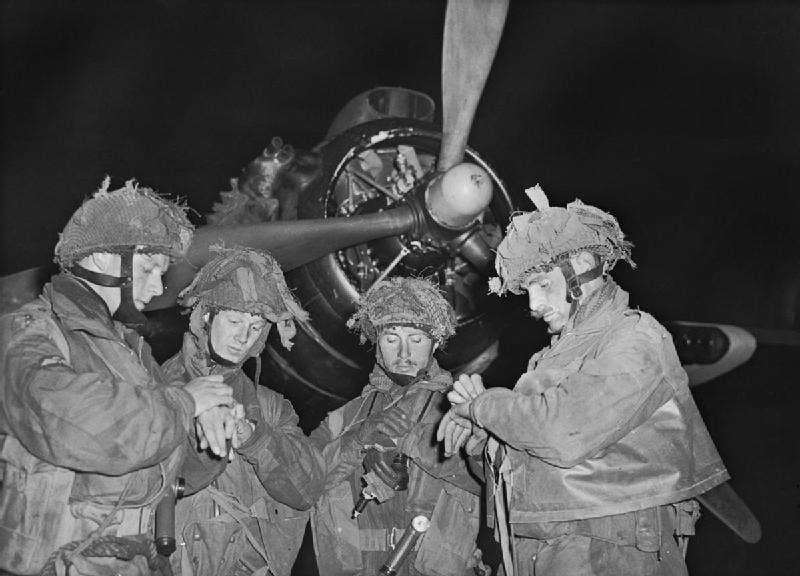 OPERATION OVERLORD (THE NORMANDY LANDINGS): D-DAY 6 JUNE 1944. The Final Embarkation: Four 'stick' commanders of 22nd Independent Parachute Company, British <a href="https://en.wikipedia.org/wiki/6th_Airborne_Division_(United_Kingdom)">6th Airborne Division</a>, synchronising their watches in front of an <a href="https://en.wikipedia.org/wiki/Armstrong_Whitworth_Albemarle">Armstrong Whitworth Albemarle</a> of No 38 Group, Royal Air Force, at about 11 pm on 5 June, just prior to take off from RAF Harwell, Oxfordshire.