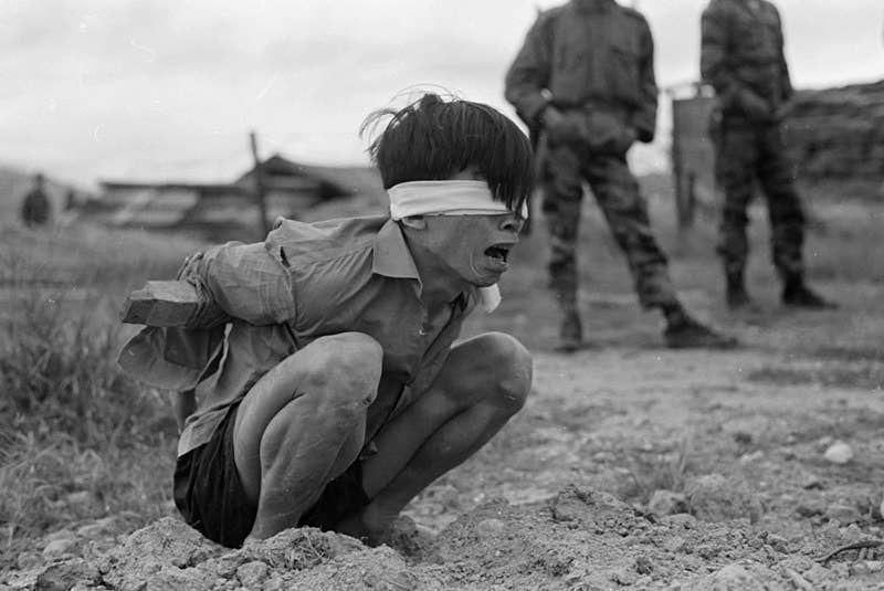 A Viet Cong prisoner captured in 1967 by the U.S. Army awaits interrogation. (Public domain)