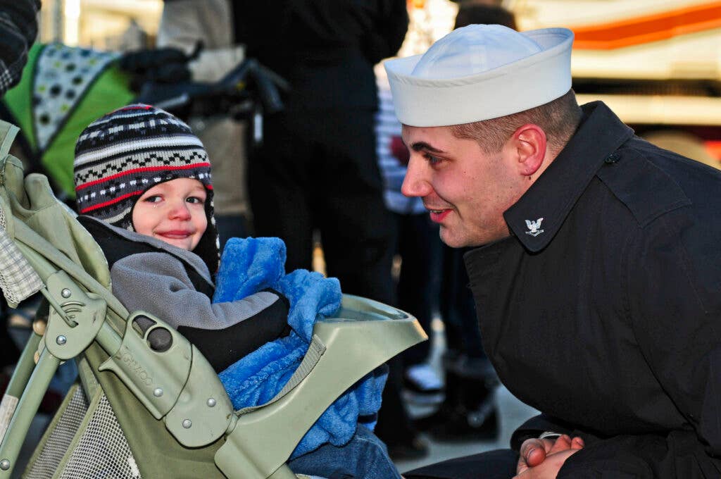 Petty Officer 3rd Class Robert Lunsford, an electronics technician, says good-bye to his son as the Arleigh Burke-class guided-missile destroyer USS Barry (DDG 52) prepares to depart Naval Station Norfolk. Barry is deploying as part of the Enterprise Carrier Strike Group supporting maritime security operations and theater security cooperation efforts in the U.S. 5th and 6th Fleet areas of responsibility. (Photo by: Petty Officer 3rd Class Jonathan Sunderman)