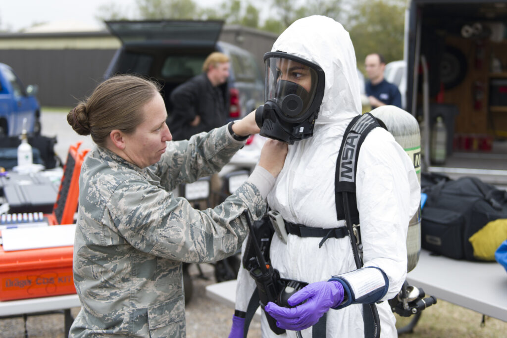 Capt. Rebekha Collins, 82nd Aerospace Medicine Squadron Bioenvironmental Engineering Flight commander, helps Airman 1st Class Carla Koenig don protective gear Nov. 3 during a hazardous materials exercise. The flight spents parts of the previous six weeks going over procedures and training, which culminated with the scenario. (U.S. Air Force photo by Alan Quevy)