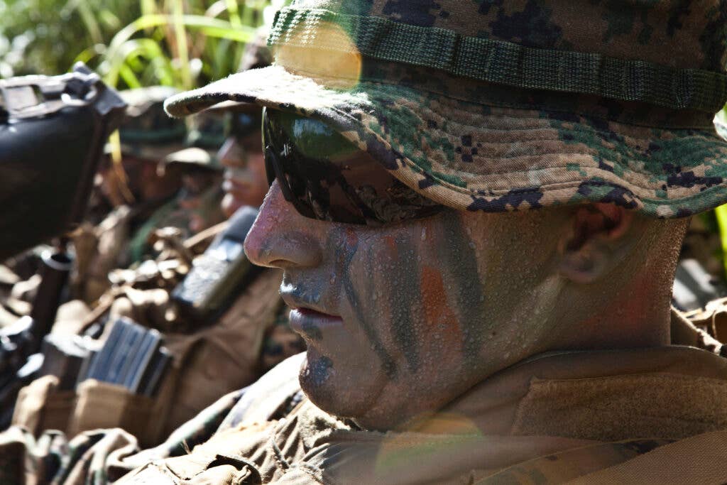 U.S. Marines attending Infantry Squad Leaders Course, School of Infantry, West, rest during a hike on the  Army's Kahuku Training Area, Hawaii, Aug. 30, 2011. The mission of ISLC is to train infantrymen to be able to take charge of Marines in a combat environment.