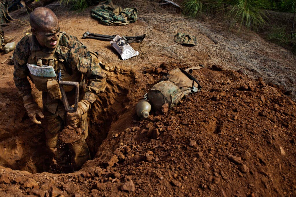 U.S. Marine Corps Lance Cpl. Herbert James, a student attending Infantry Squad Leaders Course, School of Infantry, West, digs a defense fighting hole on the  Army's Kahuku Training Area, Hawaii, Aug. 31, 2011.The mission of ISLC is to train infantrymen to be able to take charge of Marines in a combat environment.