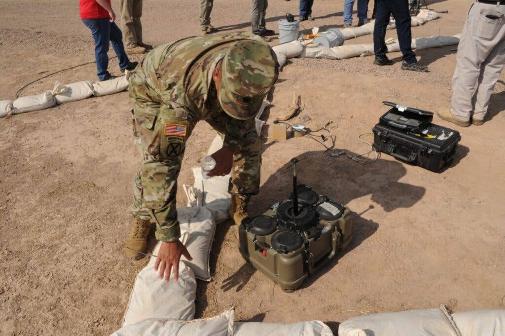 <em>A soldier emplaces an XM204 during testing at Yuma Proving Ground, Arizona (U.S. Army)</em>