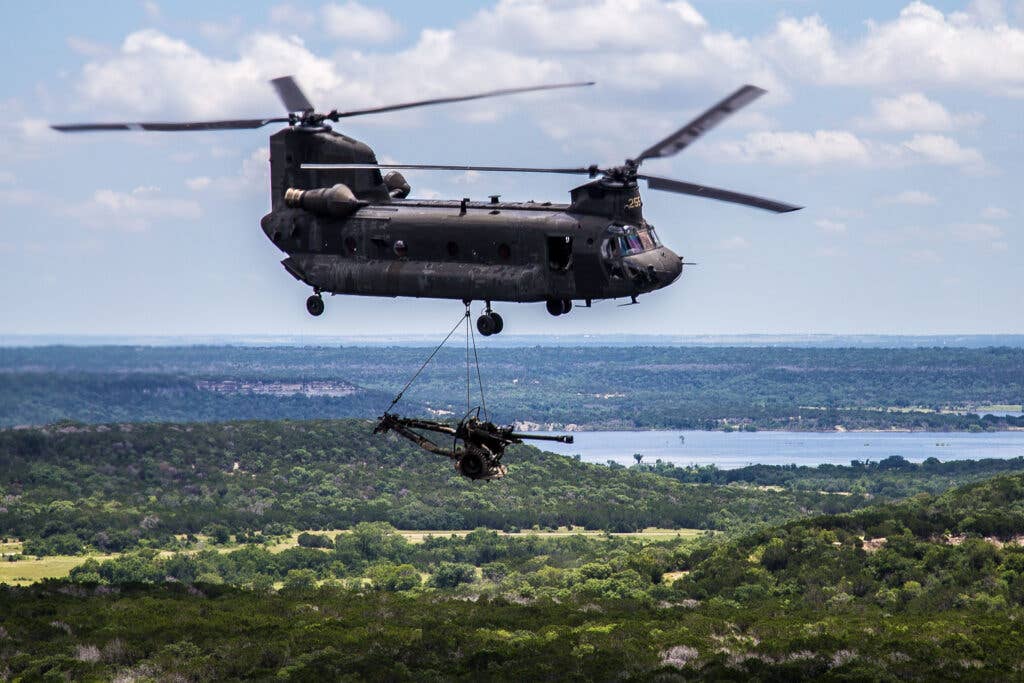 A CH-47 "Chinook" helicopter from the 2-149th General Support Aviation Battalion (GSAB) delivers a 105mm Howitzer and Soldiers from the 1st Battalion, 133rd Field Artillery during a live-fire air assault exercise. (U.S. Army photo by Maj. Randy Stillinger)