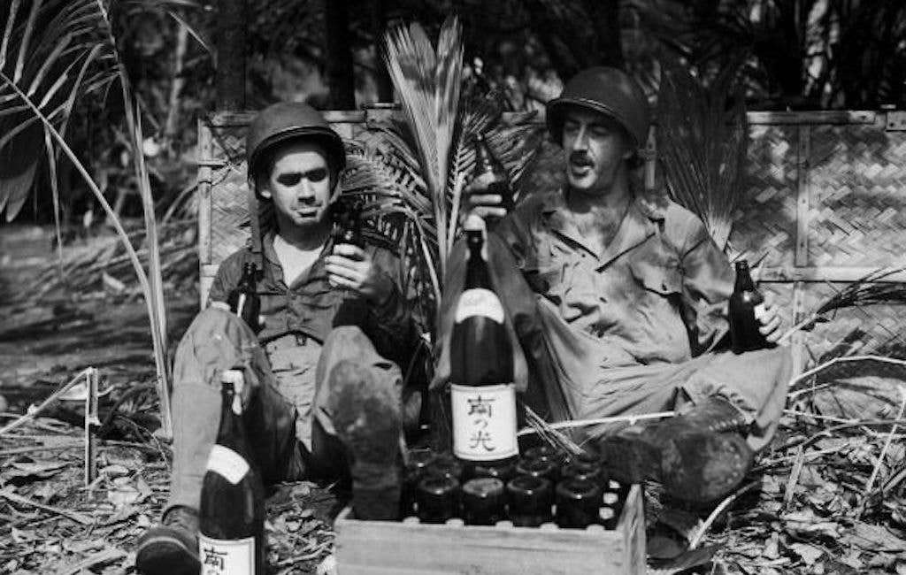 US soldiers sample some captured enemy supplies in the Pacific Theatre. Soldiers on campaign often become proficient in finding home comforts and alcohol is chief among them. (Public domain)