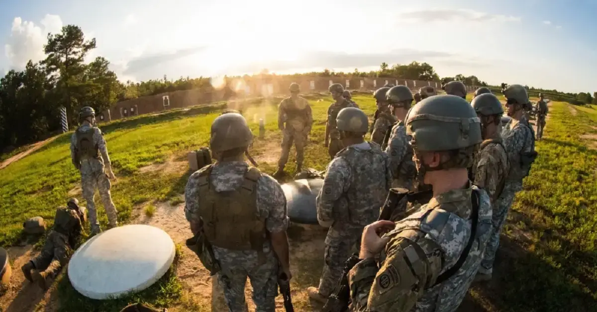a group of military personnel standing in a field for training.