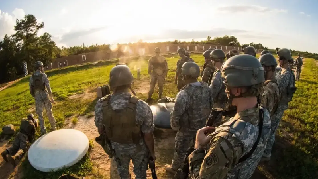 a group of military personnel standing in a field for training.