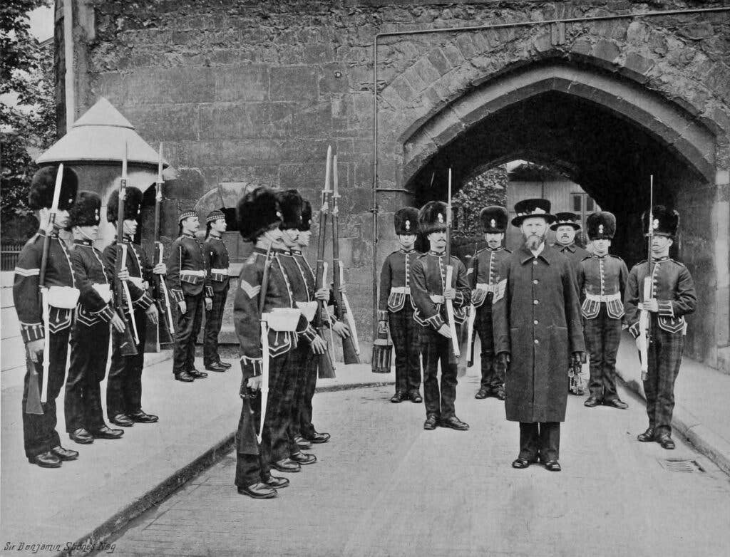A guard of the Royal Scots Fusiliers escorting Yeoman Warders during the Ceremony of the Keys, <em>circa</em> 1900.