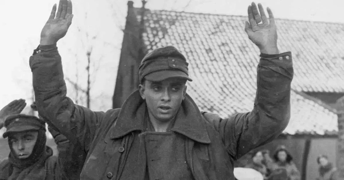 captured troops raising their hands in pow camp.